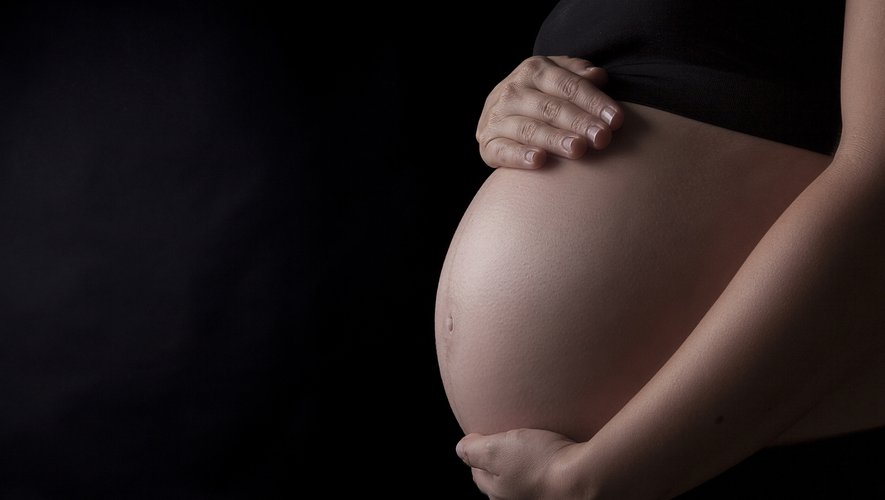 Midsection Of Pregnant Woman Touching Her Belly, Studio shot